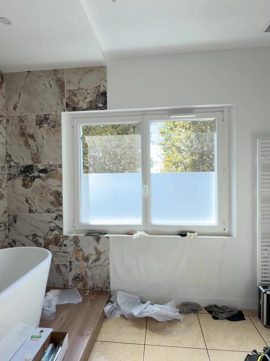 Salle de bain avec baignoire îlot à Hyères, fenêtre traitée en film dépoli sur la partie basse par PrivTeint
