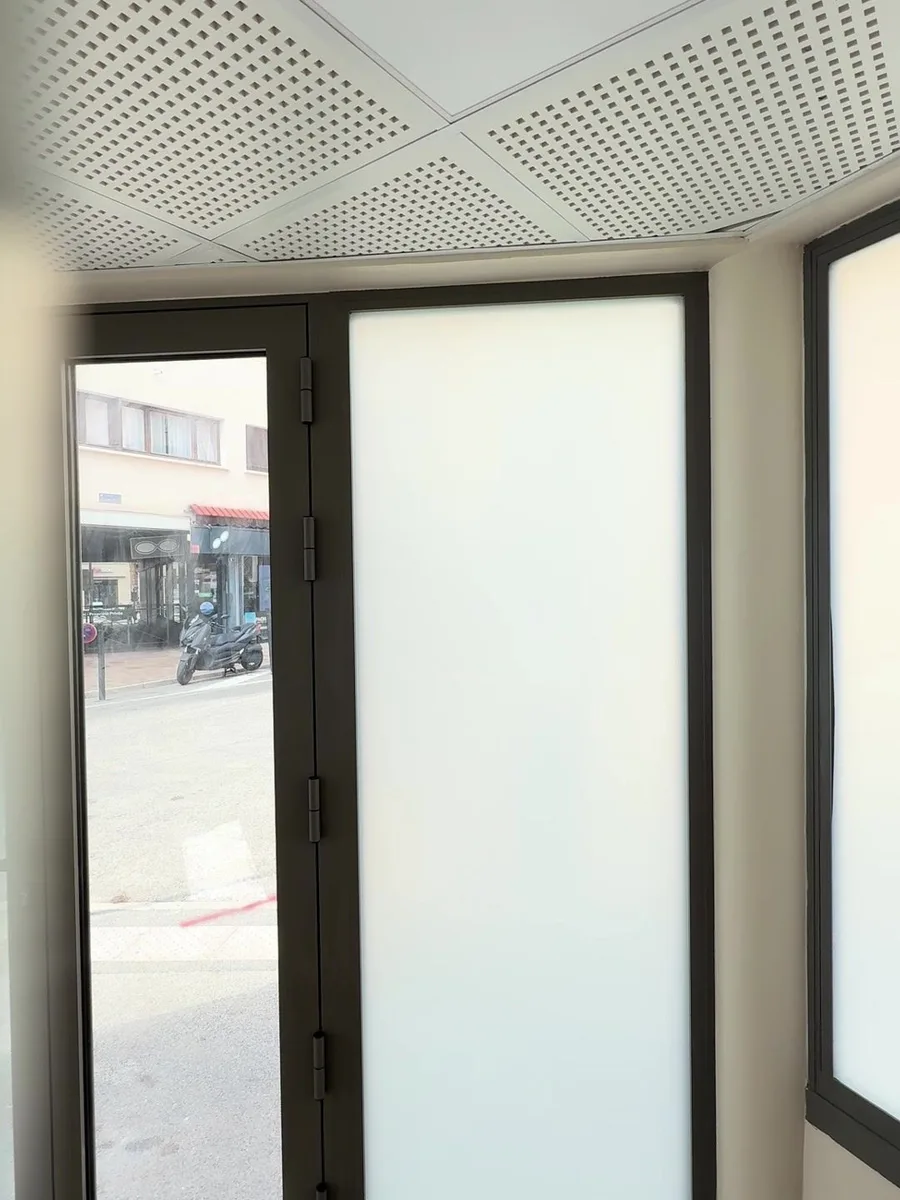 Fin de pose : porte vitrée transparente à côté d'une vitrine pleine hauteur en film dépoli, dans le local commercial à Hyères.