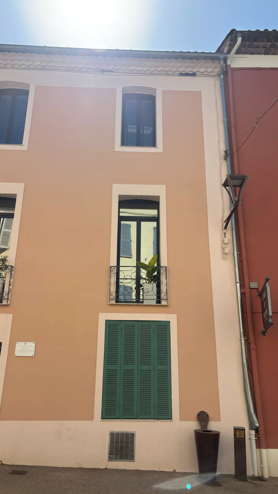 Façade d'immeuble à Saint-Raphaël : porte-fenêtre à balcon équipée d'un film miroir sans tain PrivTeint, qui renvoie les volets de l'immeuble d'en face