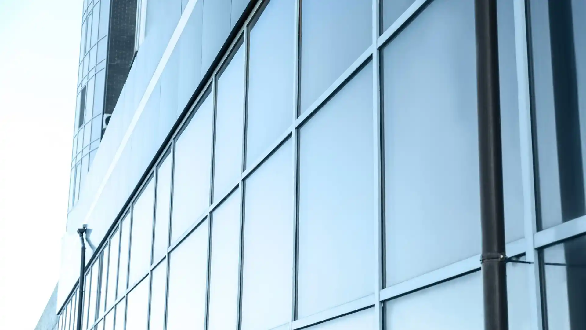 Façade vitrée d'un immeuble de bureaux équipée d'un film solaire de protection thermique, dans le Var.