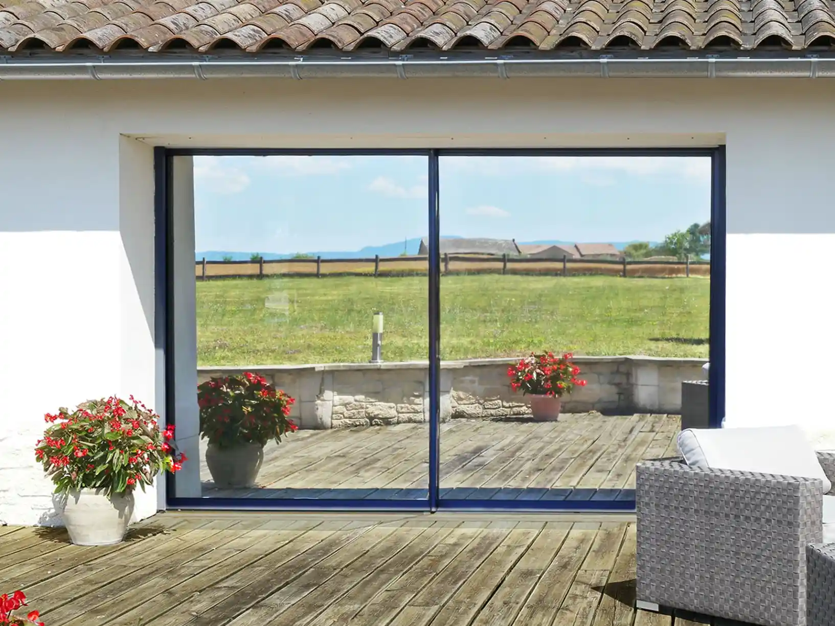 Baie vitrée donnant sur une terrasse, traitée par film solaire, dans une maison du Var