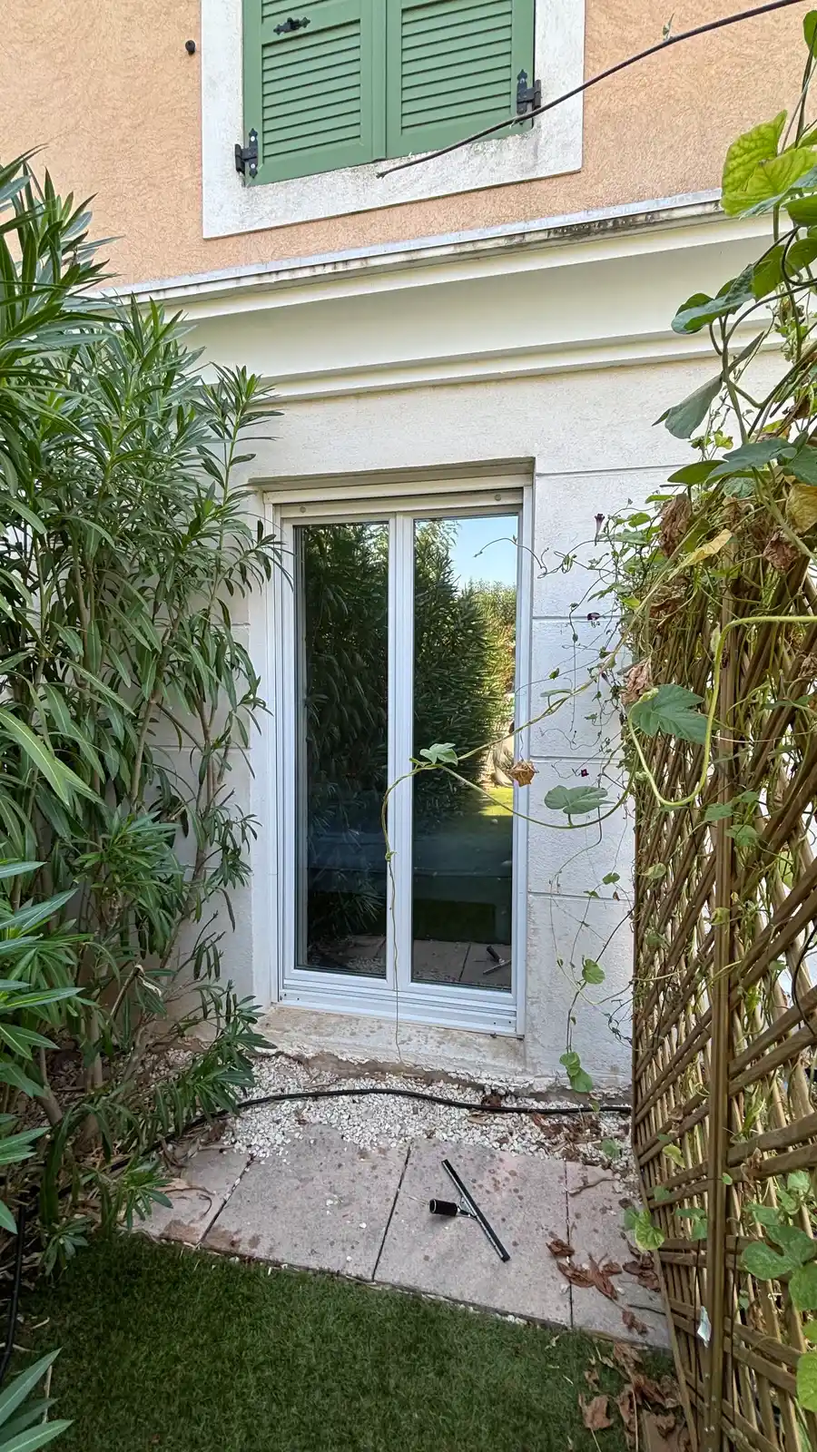 Baie vitrée de chambre équipée du film miroir sans tain à Hyères, reflet des lauriers et du ciel
