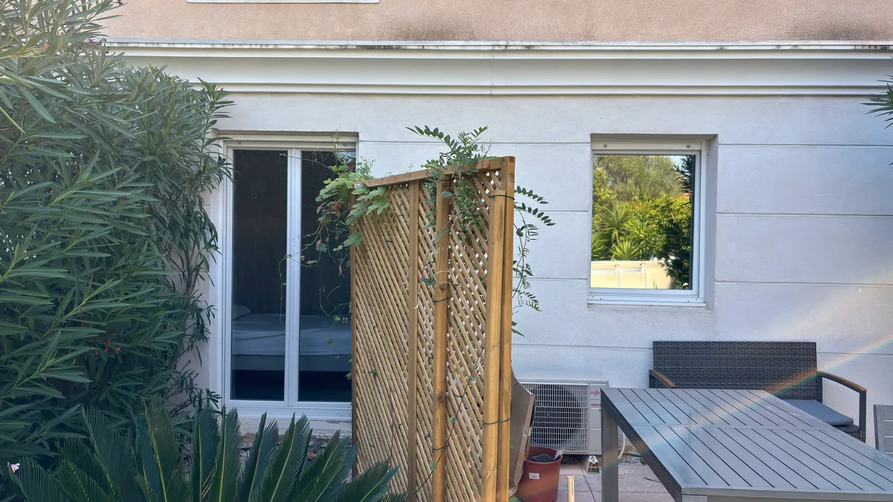 Pose en cours d'un film miroir sans tain à Hyères : la fenêtre de droite, déjà filmée, reflète le jardin, tandis que la baie vitrée de gauche, non traitée, laisse voir la chambre.