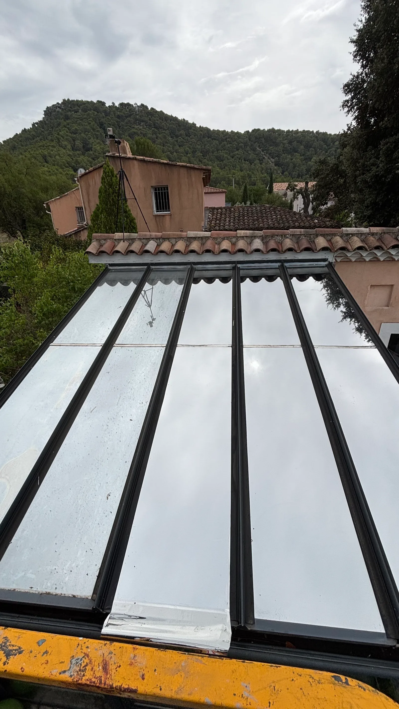 Deux techniciens PrivTeint en nacelle araignée posant un film solaire sur la toiture vitrée d’une véranda dans le Var