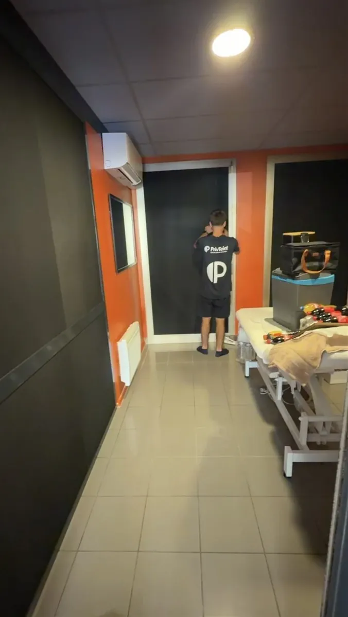 Technicien PrivTeint posant un film sur une porte vitrée d'institut à Hyères