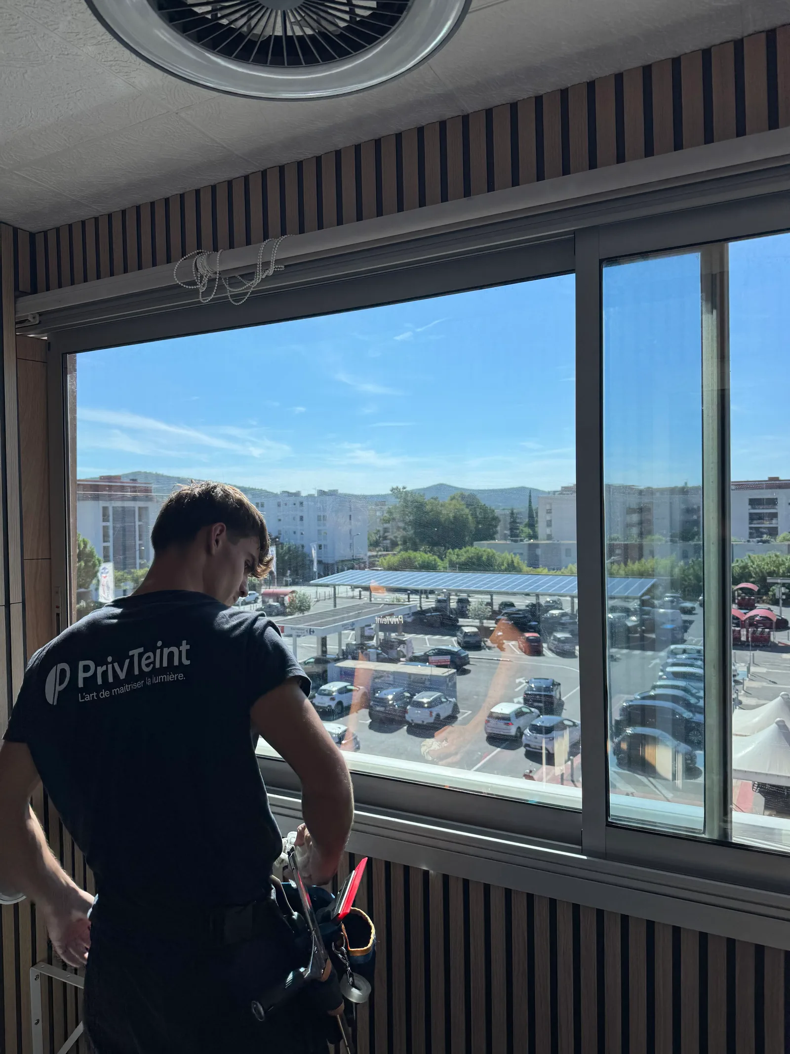 Technicien PrivTeint posant un film sur un vitrage de bureau dans le Var