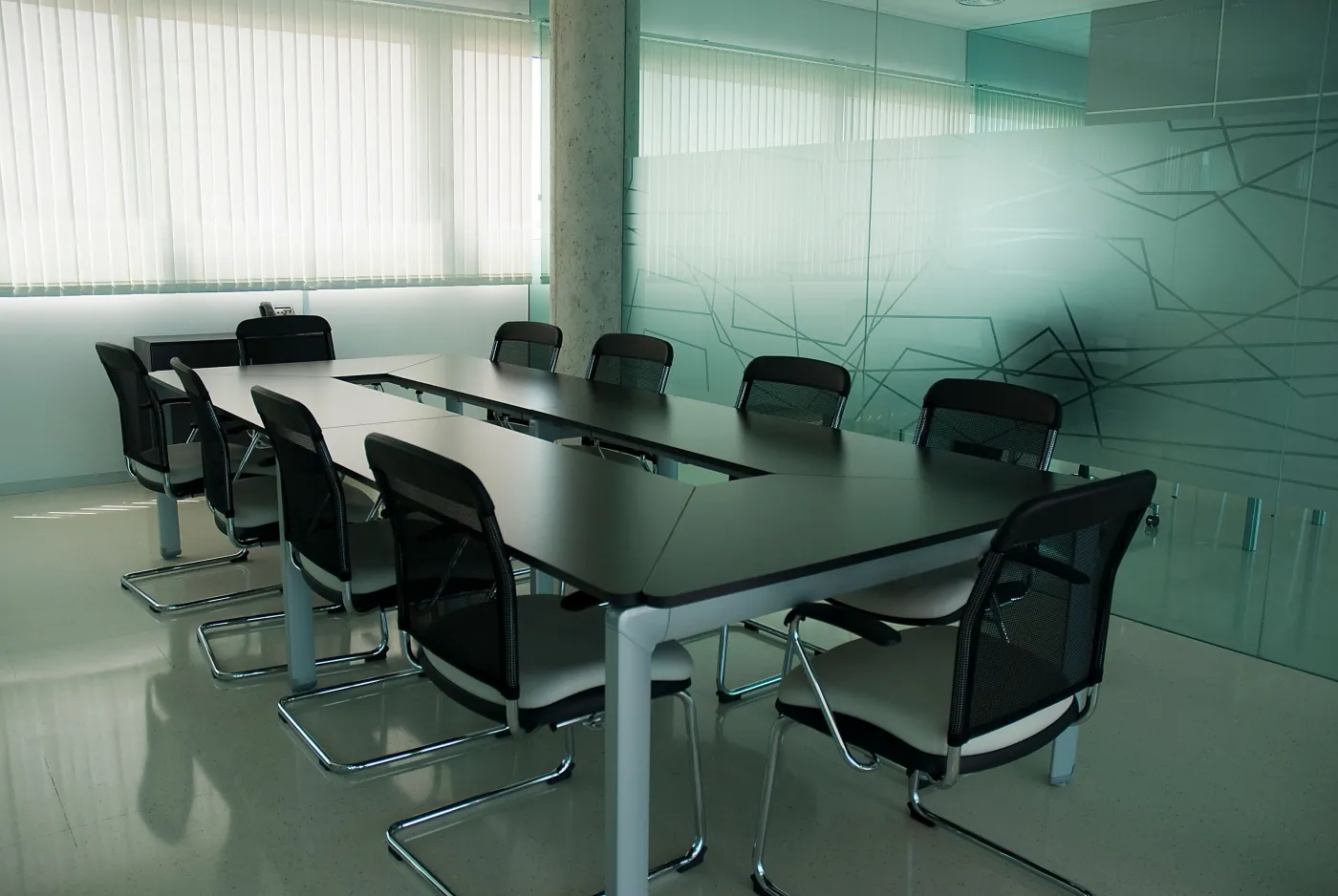 Salle de réunion avec cloison vitrée habillée d'un film dépoli à motif géométrique, confidentialité et décoration