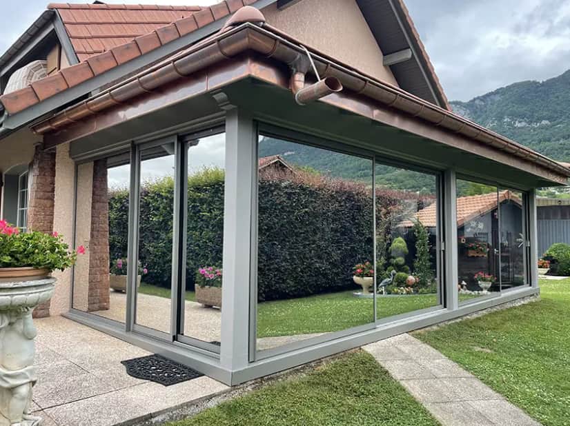 Véranda vitrée avec film solaire anti-chaleur PrivTeint, réduction de l’éblouissement et protection UV pour le confort intérieur.